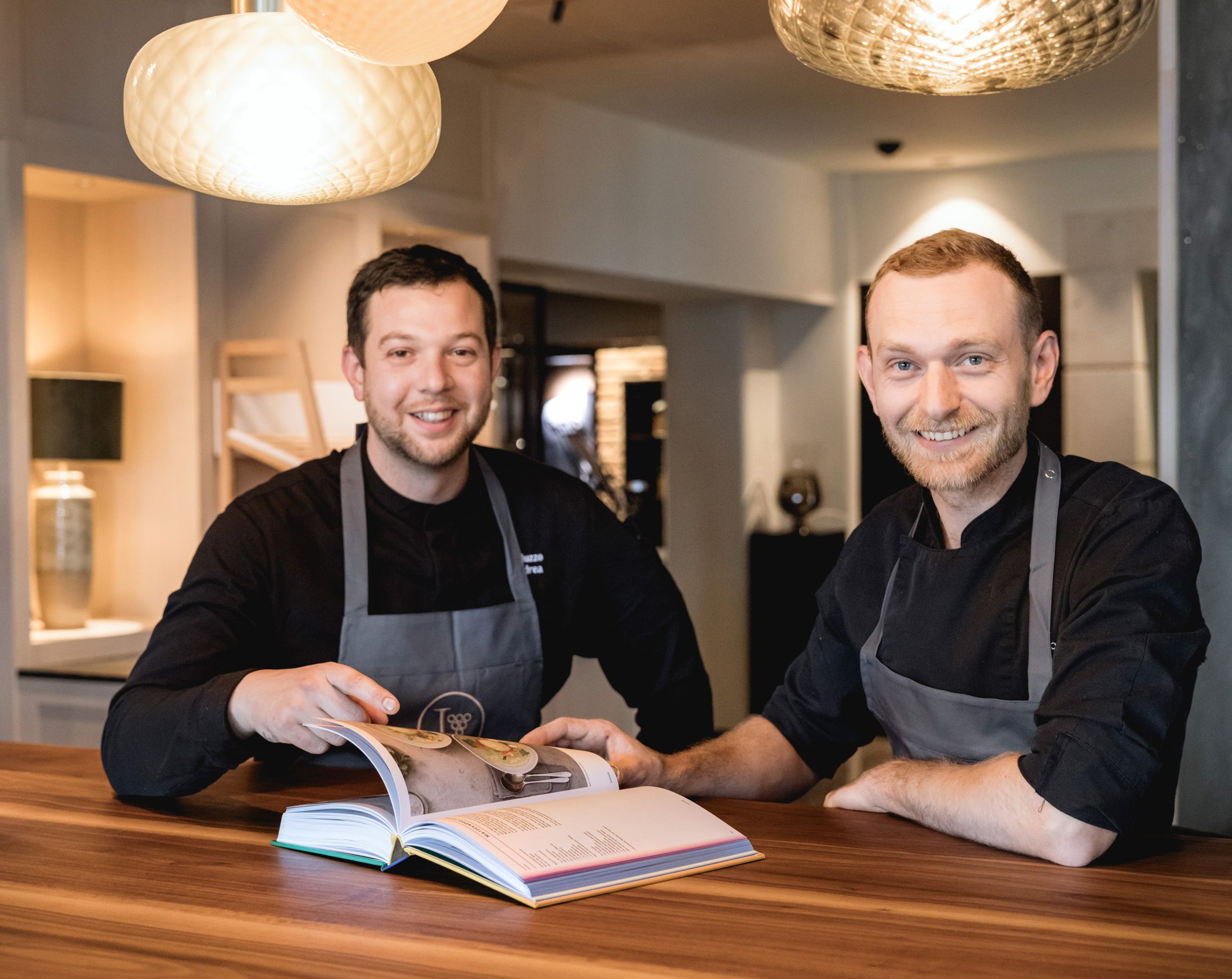Chefkoch Andrea und Sous Chef Thomas sitzen am Tisch