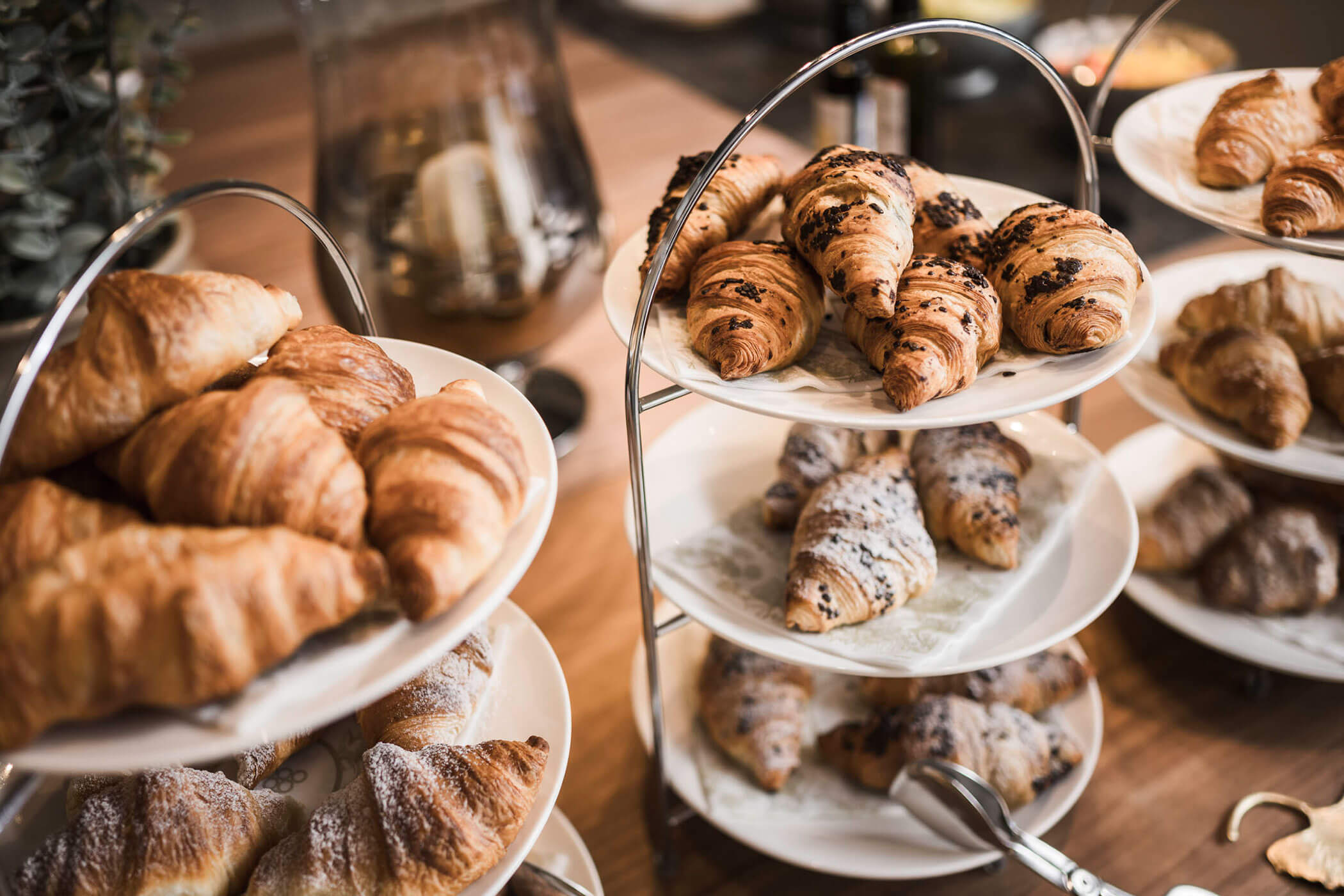 Assorted croissants displayed on tiered trays at a bakery or café. - Hotel Lagrein